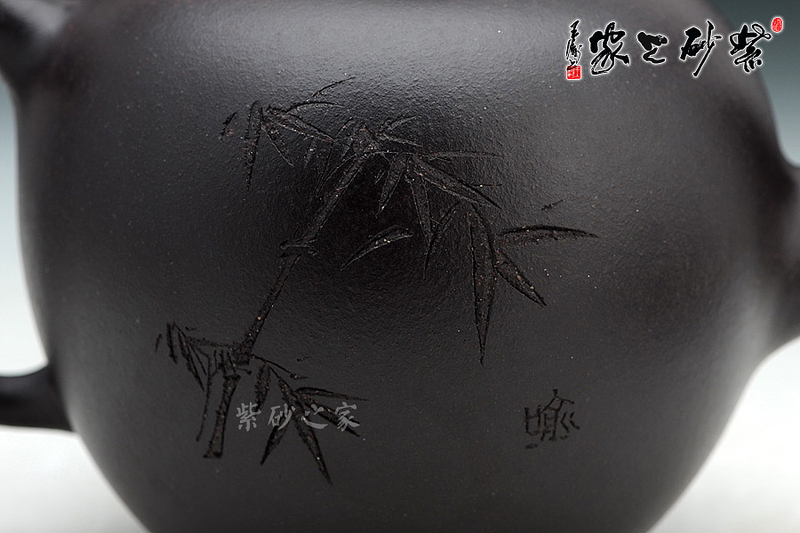 大圆珠壶,560cc,全手工壶,内行人士都知道,壶艺创作中,器型大制作难度也就大,这是对艺人手上功力的绝好考量,足以见证艺人的升值空间。这款壶精气神俱备,堪称精品。 老师家藏黑拼紫泥制作而成,圆润的身体,嵌盖,椭圆形柱钮倒立在壶盖之上,整款壶亭亭玉立,秀美颀长,犹如一位江南女子,清洁如玉。二弯流,曲折柔韧;耳形把,阔大规整。冯勤芳老师作为光货艺人,连在壶身上刻绘也是惜墨如金;偌大的一款壶,壶身装饰由国家一级美术师喻继高题写,壶身正面两个行书标明趣味所在,反面两枝竹子飒飒作响,枝叶稀疏,生怕过多的附会破坏了