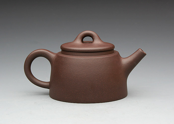 嘴,整器简洁明快,如钟似帽,古穆疑重,刚劲古雅,构思别致,名曰"鱼罩壶"